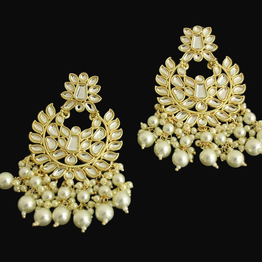 Gold and pearl earrings on a dark background with 'Saheli' branding.