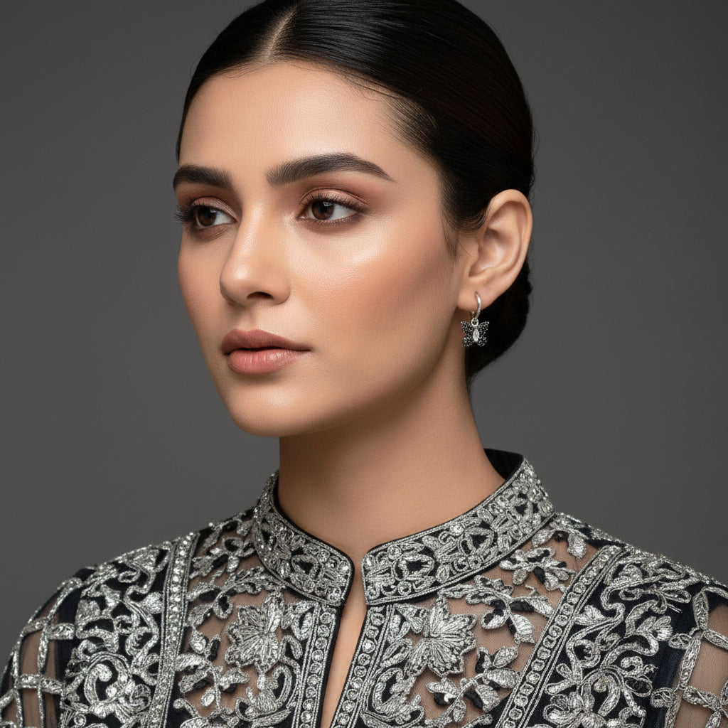 Silver butterfly earrings on a gray background with 'Saheli' branding.