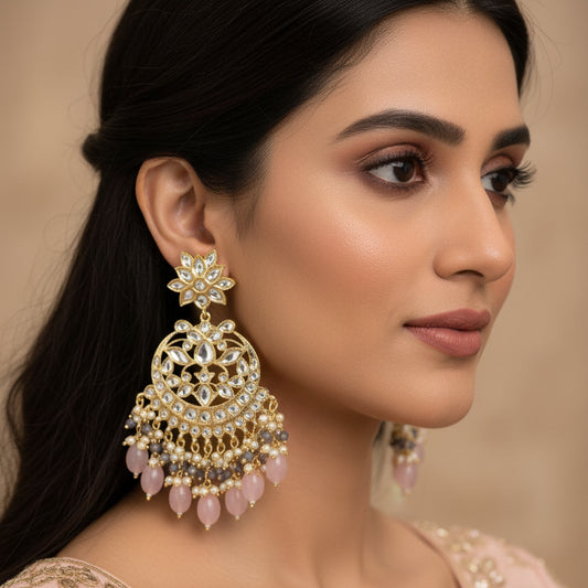 Ornate earrings with pink stones on a dark background, branded 'SAHELI'.