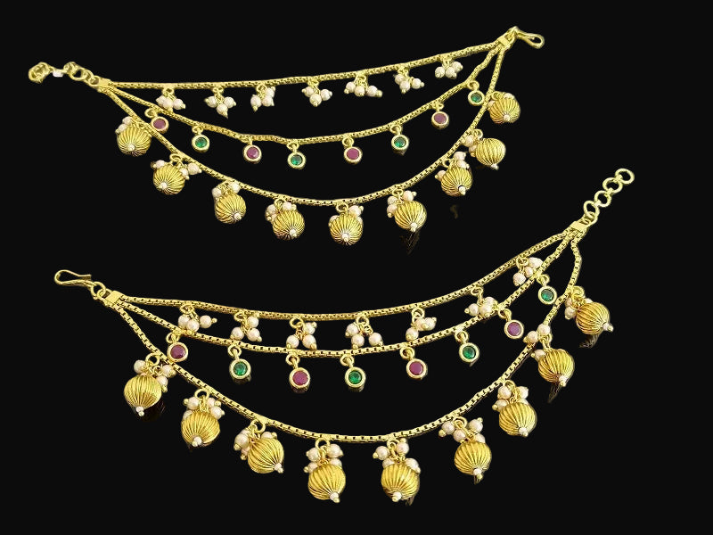 Gold jewelry set with multiple layers and colorful stones on a dark background, branded 'SAHELI'.