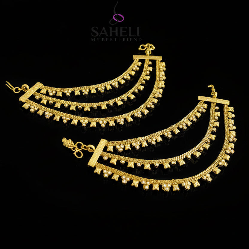 Two gold necklaces with intricate designs on a dark background, branded 'Saheli'.