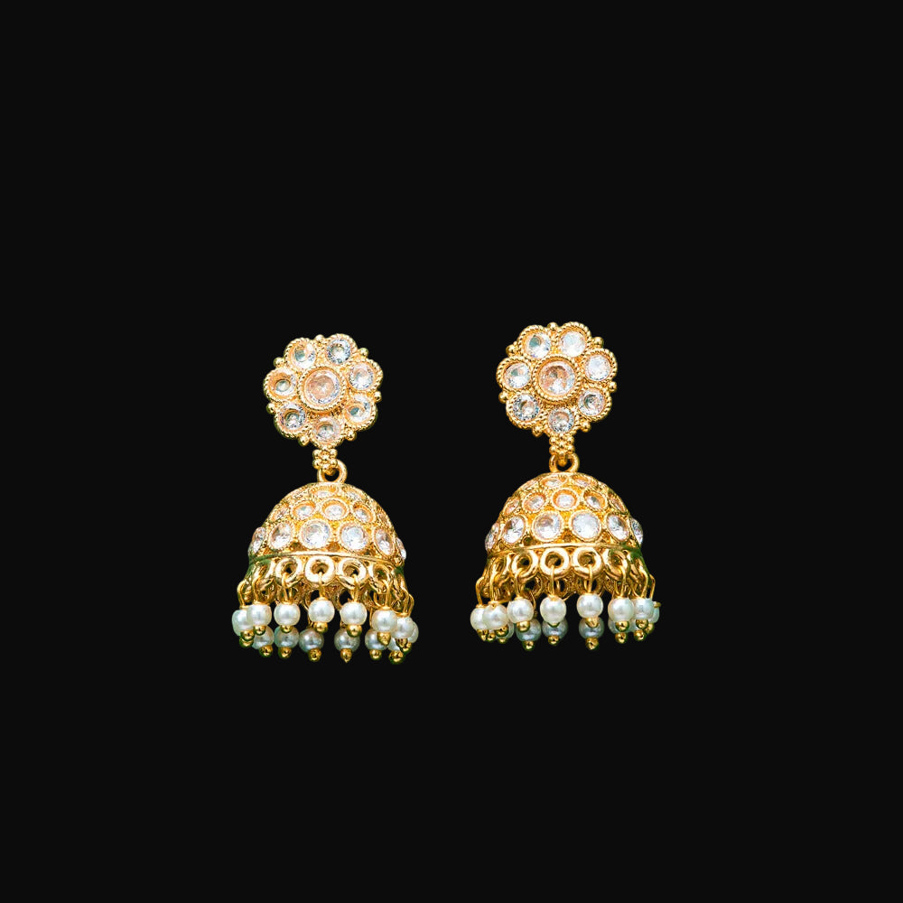 Gold and pearl earrings on a teal background