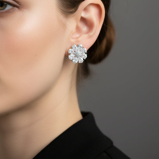 Pair of diamond earrings on a gray cushion with a dark background