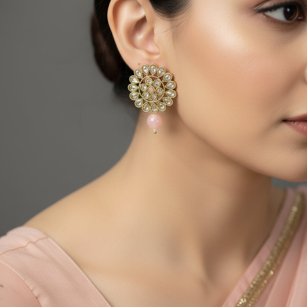 Pair of gold and gemstone earrings on a dark background