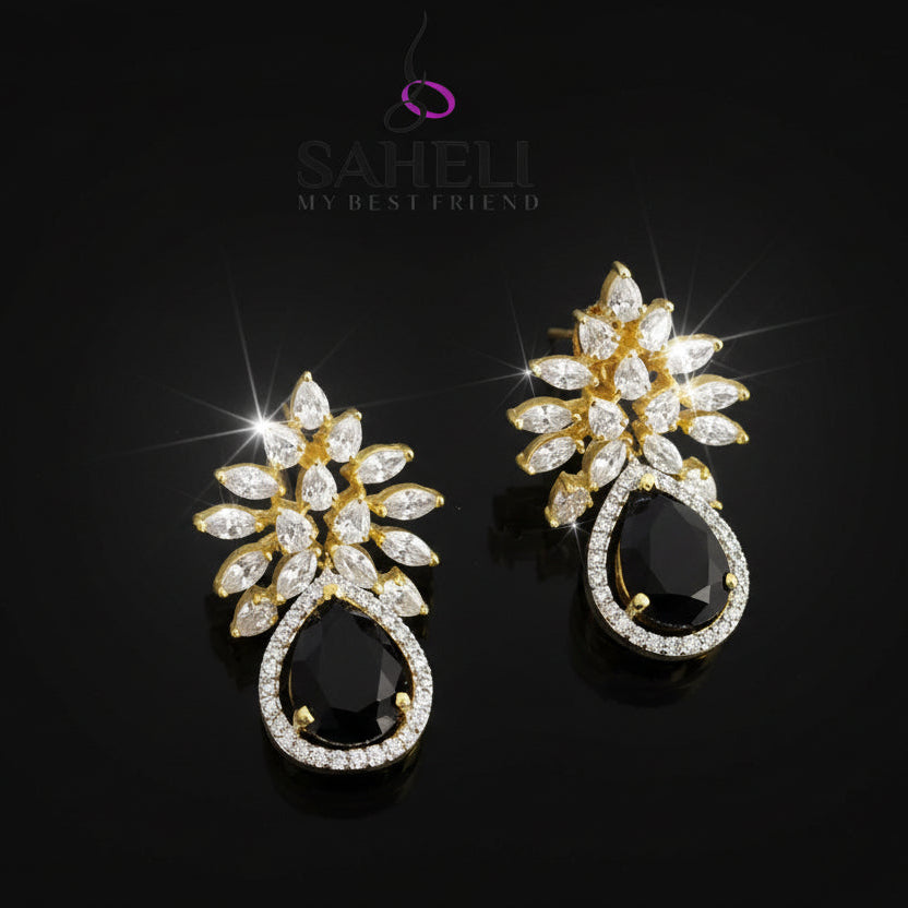 Gold and black earrings with 'Saheli' branding on a dark background