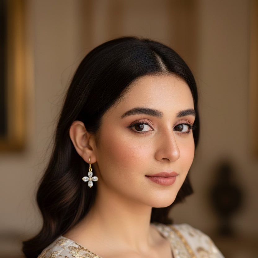 Gold earrings with clear gemstones on a dark gray background