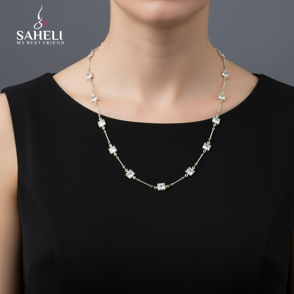 Silver necklace with square-shaped crystals on a black background, branded 'Saheli'.