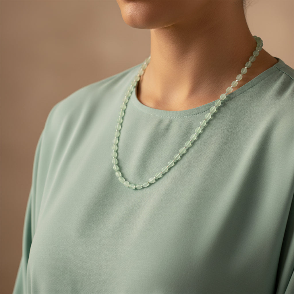 Green beaded necklace on a dark gray background