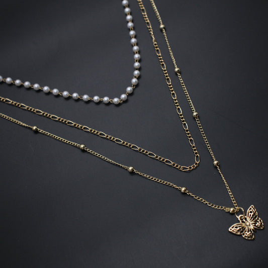 Three necklaces with different designs on a dark background