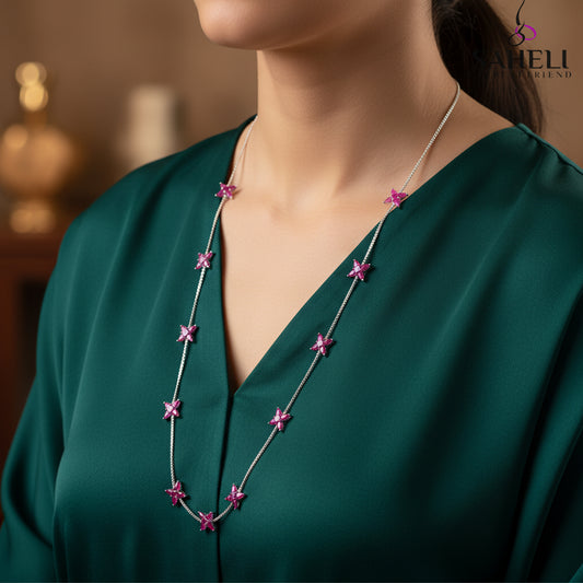 Necklace with pink flower pendants on a gray background, featuring the brand 'Saheli'.