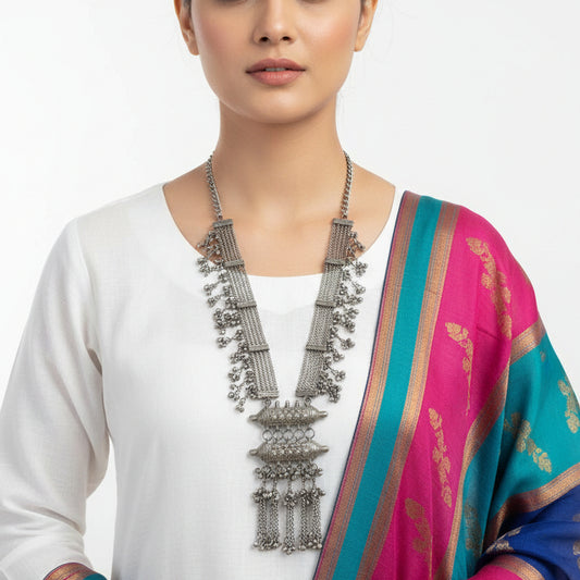 Silver necklace with intricate designs on a reflective surface