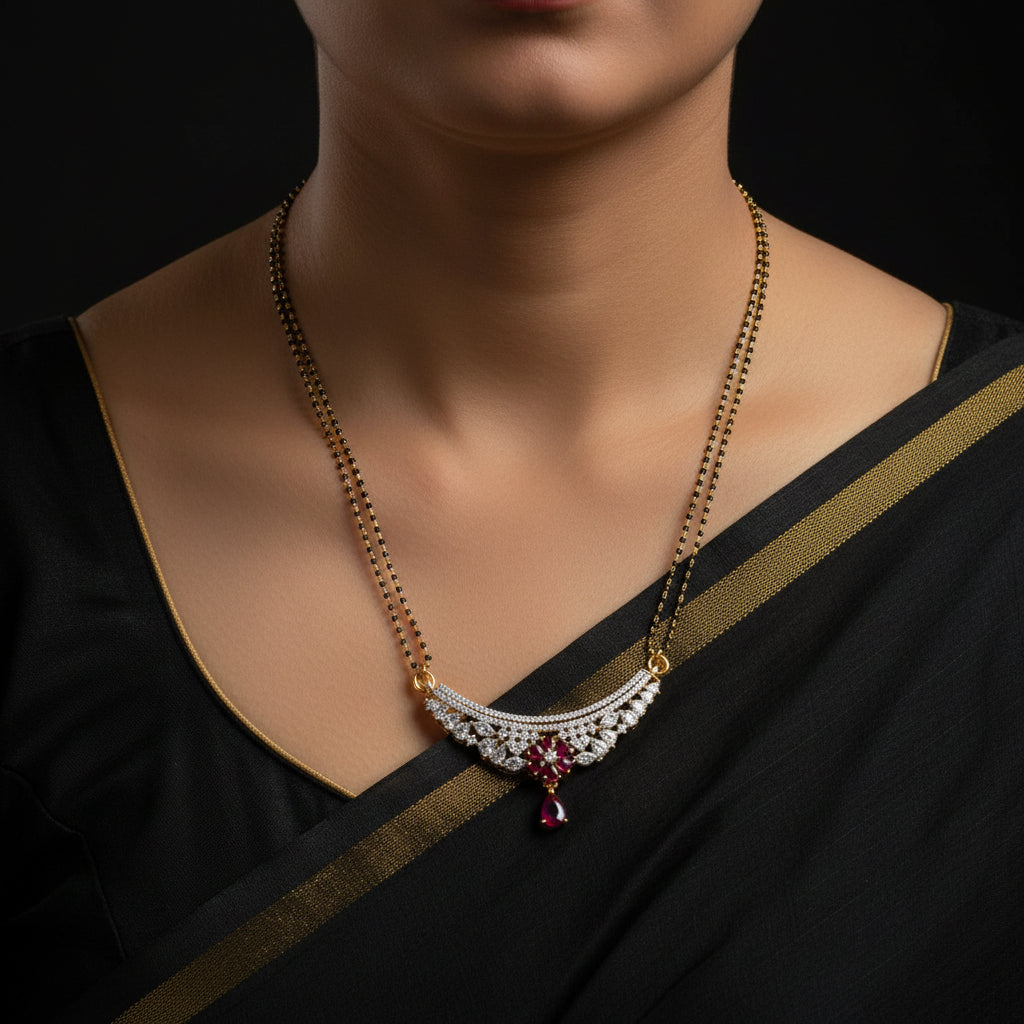 A gold chain necklace with a crescent moon pendant adorned with clear stones and a red teardrop pendant, displayed on a black background with the SAHELI MY BEST FRIEND logo in the top right.