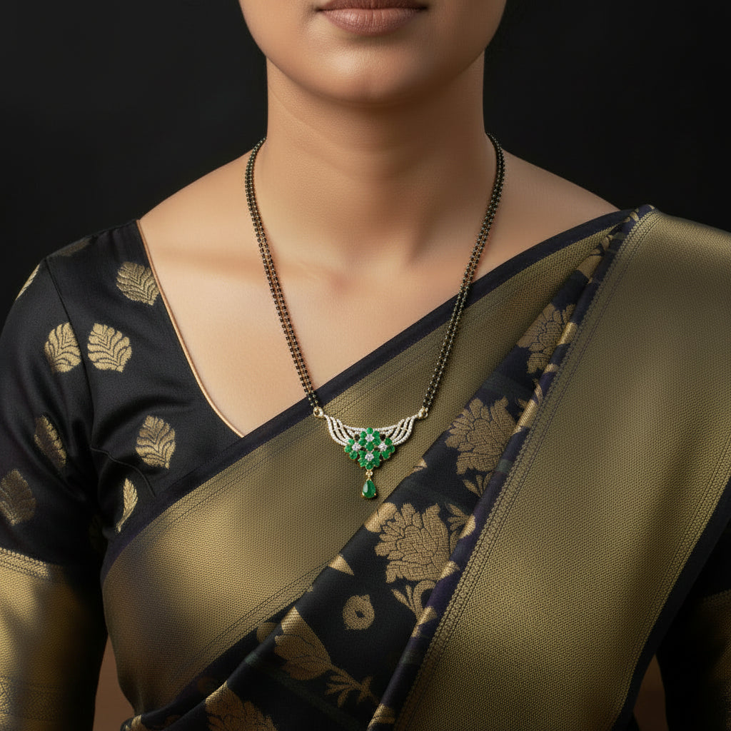 A gold-plated necklace with a black beaded chain and a wing-shaped pendant featuring green stones and small white stones, displayed on a dark reflective surface with the SAHELL MY BEST FRIEND logo in the upper right.