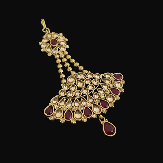 Gold and red gemstone pendant on a dark background with 'SAHELI' branding.