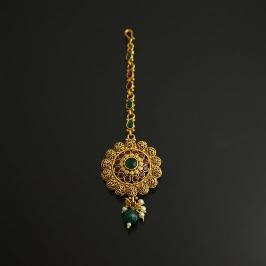 Gold necklace with green gemstones on a black background