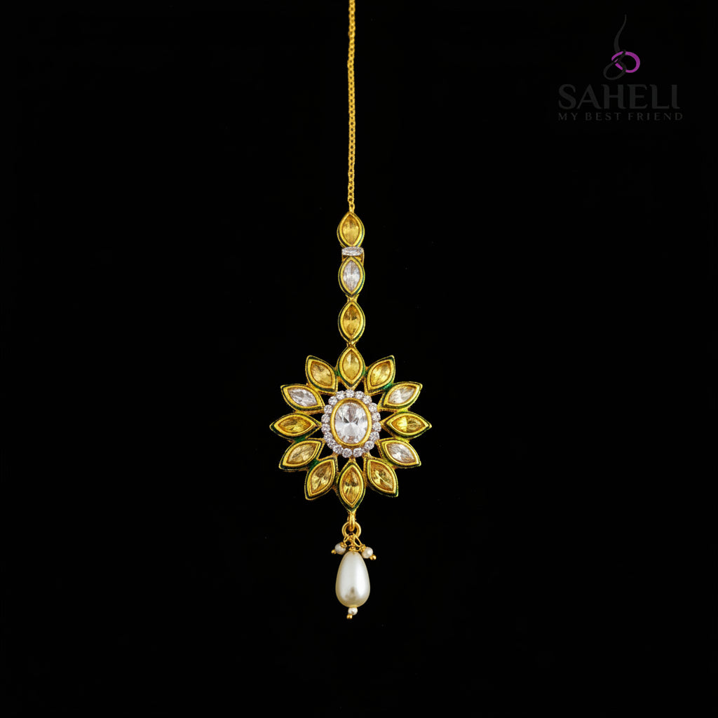 Jewelry item with floral design and pearl drop on a dark background, branded 'SAHELI'.