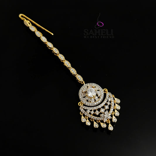 Decorative hairpin with gold and silver details on a dark background, featuring the brand 'SAHELI'.