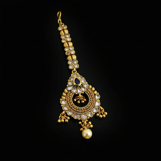 Gold necklace with intricate design on a gray background, featuring the brand 'SAHELI'.
