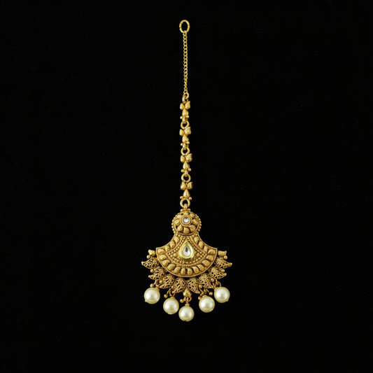 Gold necklace with pearl pendants on a gray background, featuring the brand 'Saheli'.