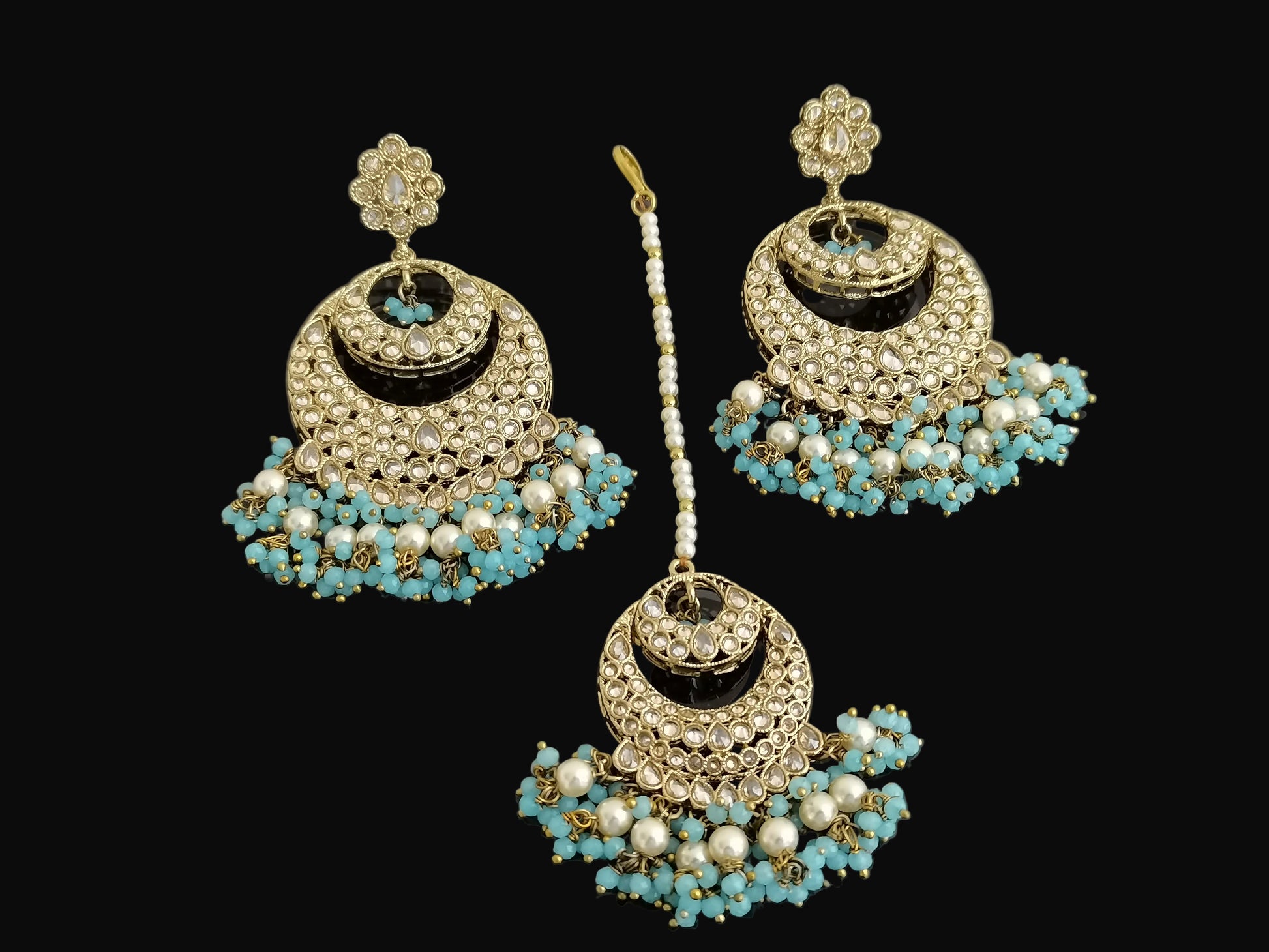 Jewelry set with earrings and a hairpin on a dark background