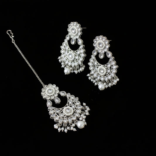 Silver jewelry set with floral designs on a dark background