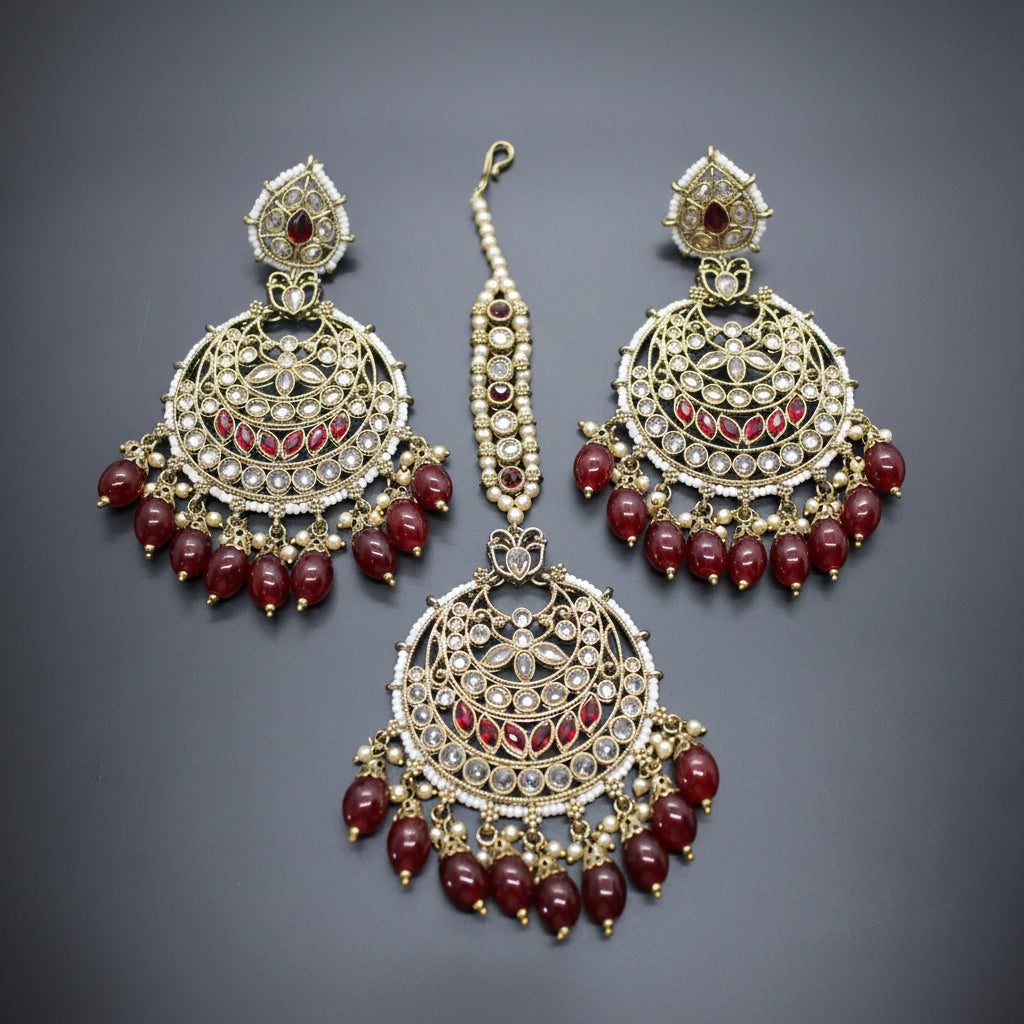 Set of gold and red jewelry on a gray background
