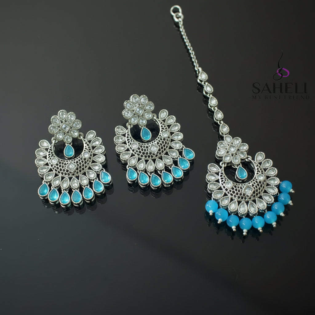 Ornate silver and turquoise earrings on a dark background with 'Saheli' branding.