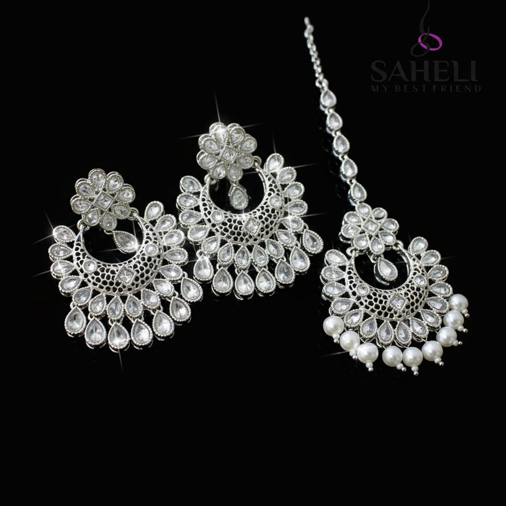Jewelry set with earrings and a necklace on a dark background, featuring the brand 'Saheli'.