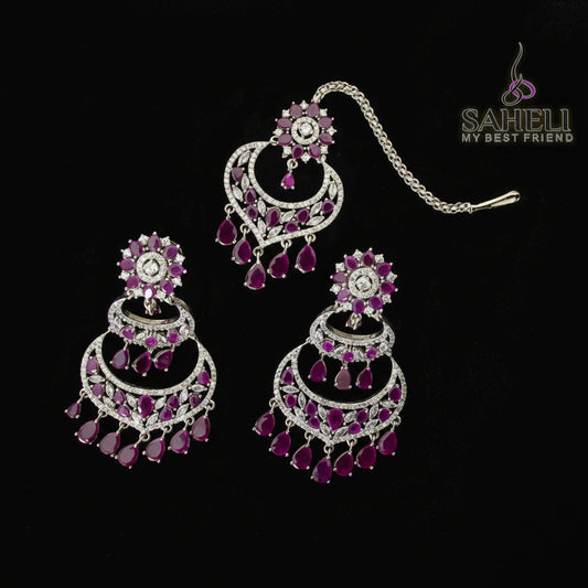 Jewelry set with pink and silver earrings on a black background