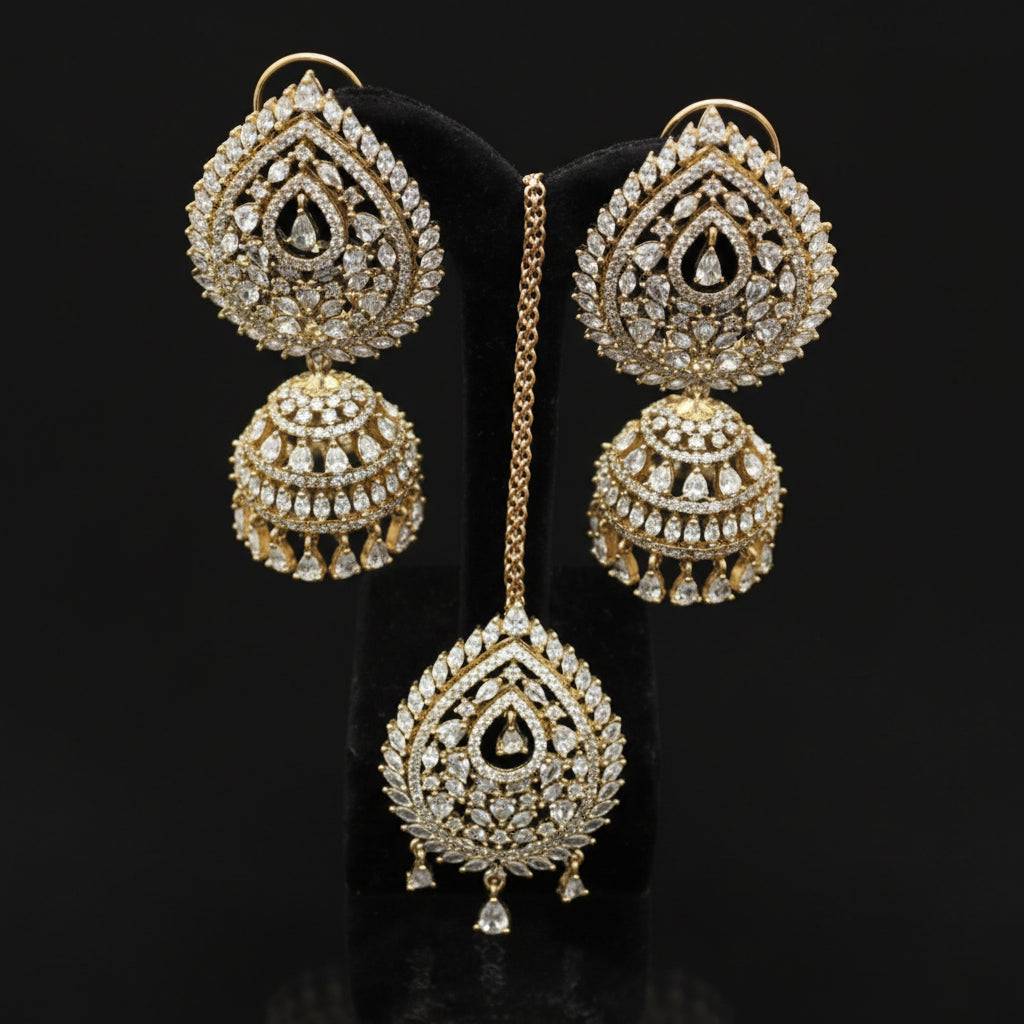 Ornate gold earrings with intricate designs on a dark stand, branded 'Saheli'.