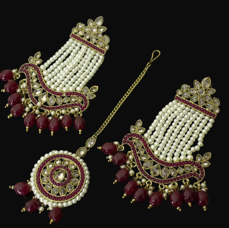 Jewelry set with maroon and gold elements on a dark background
