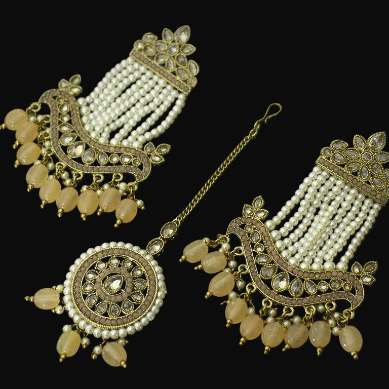 Ornate jewelry set with pearls and gold accents on a dark background