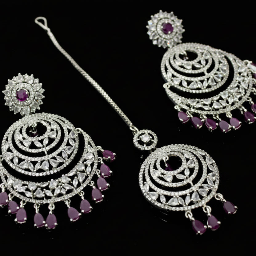 Jewelry set with earrings and a brooch on a dark background