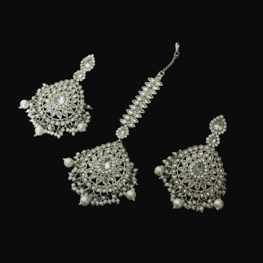 Silver jewelry set with necklace and earrings on a black background