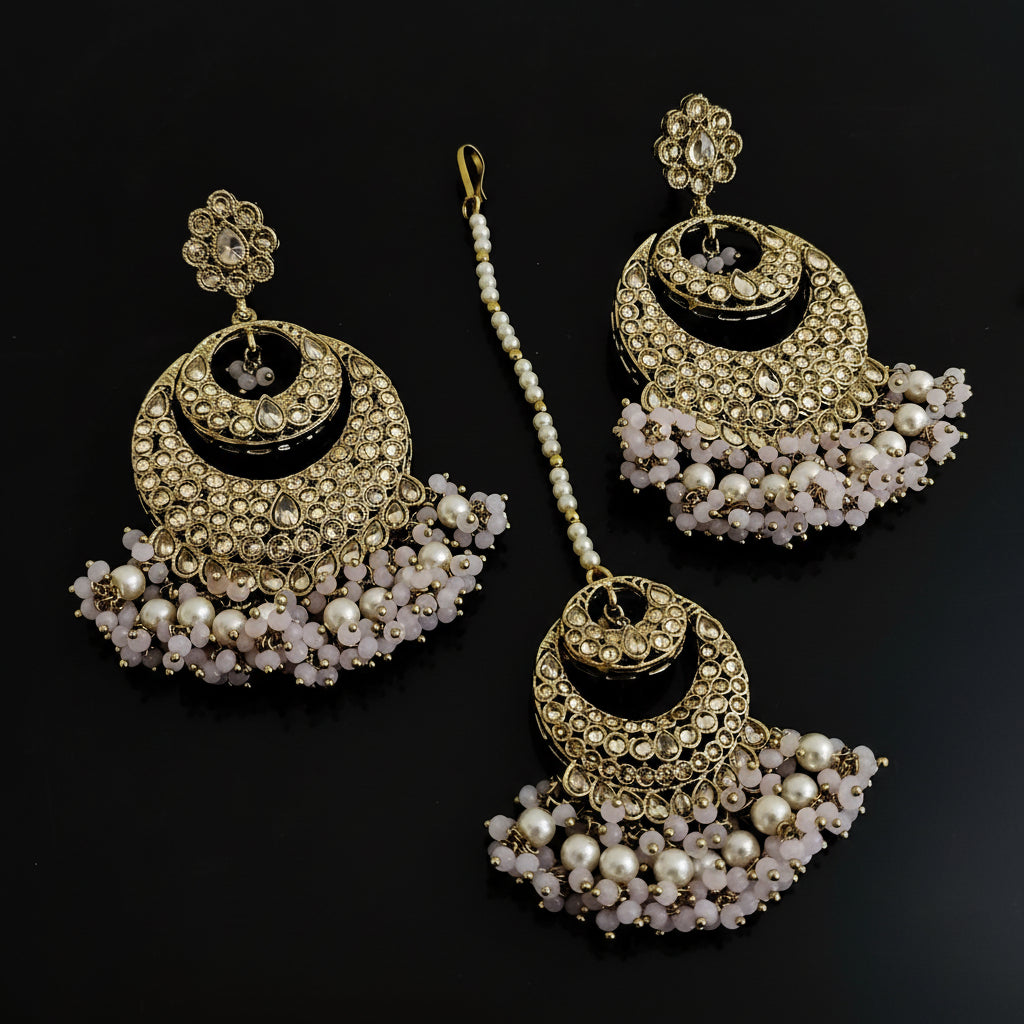 Set of gold and pearl earrings on a dark background