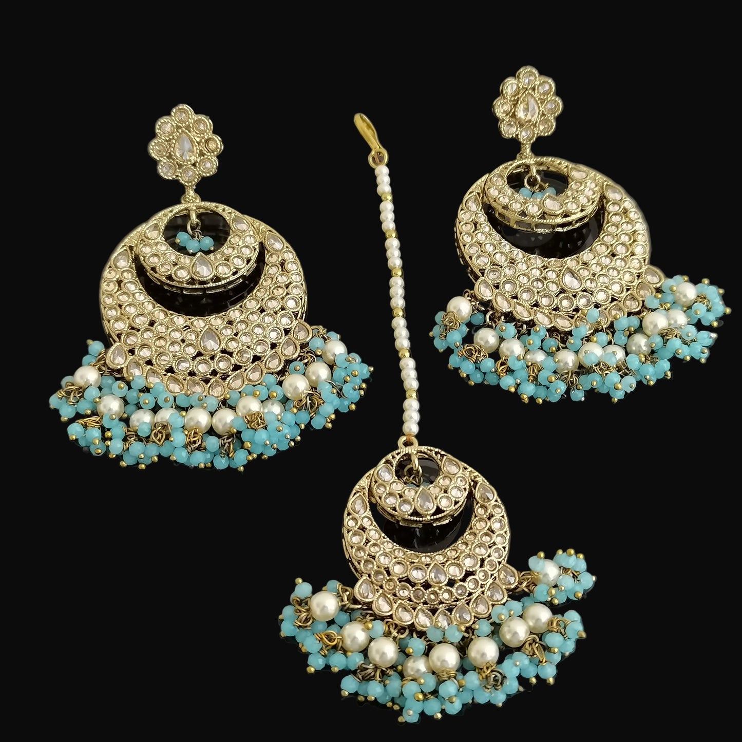 Jewelry set with earrings and a hairpin on a dark background