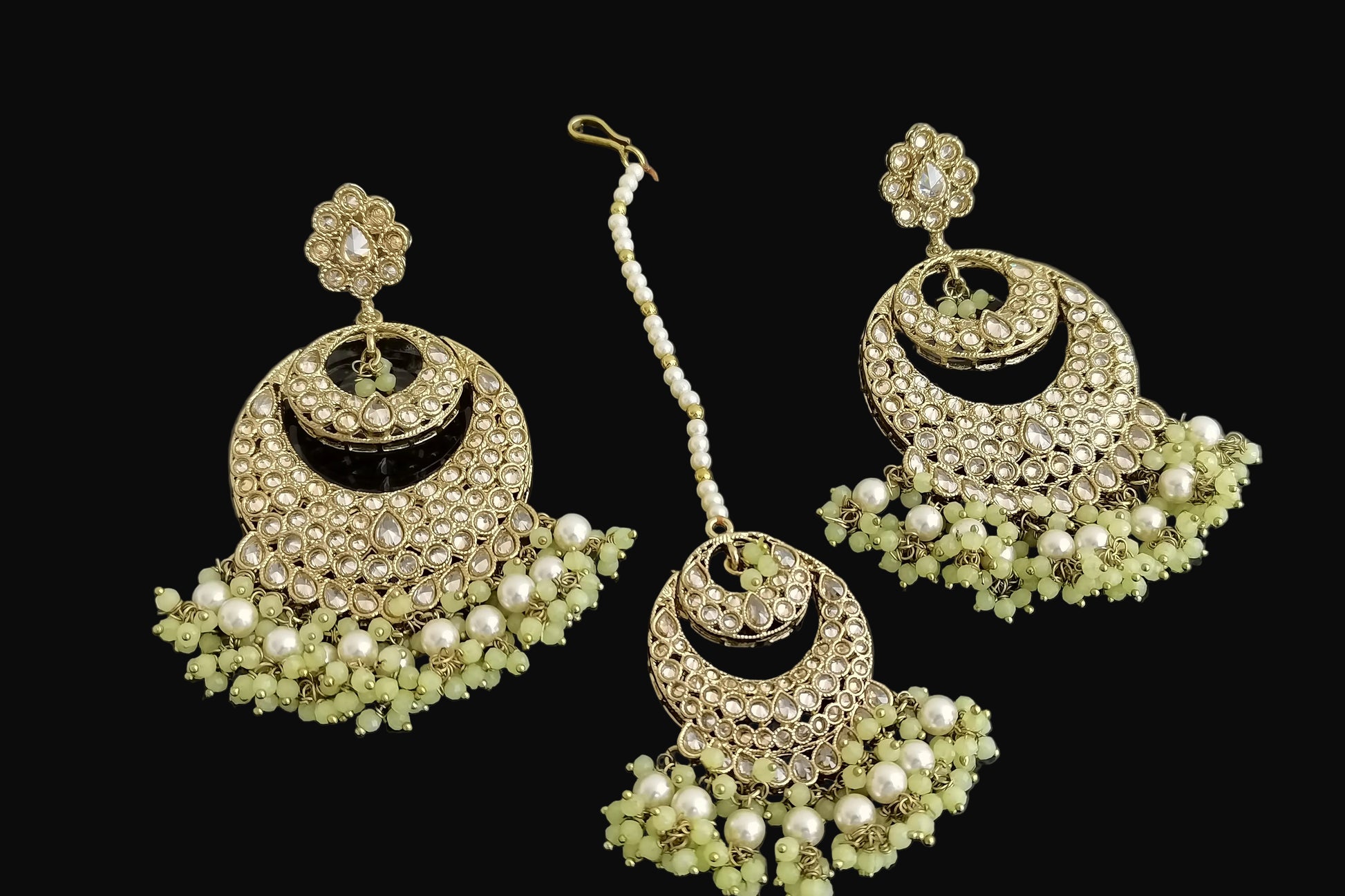 Gold and pearl jewelry set on a dark background