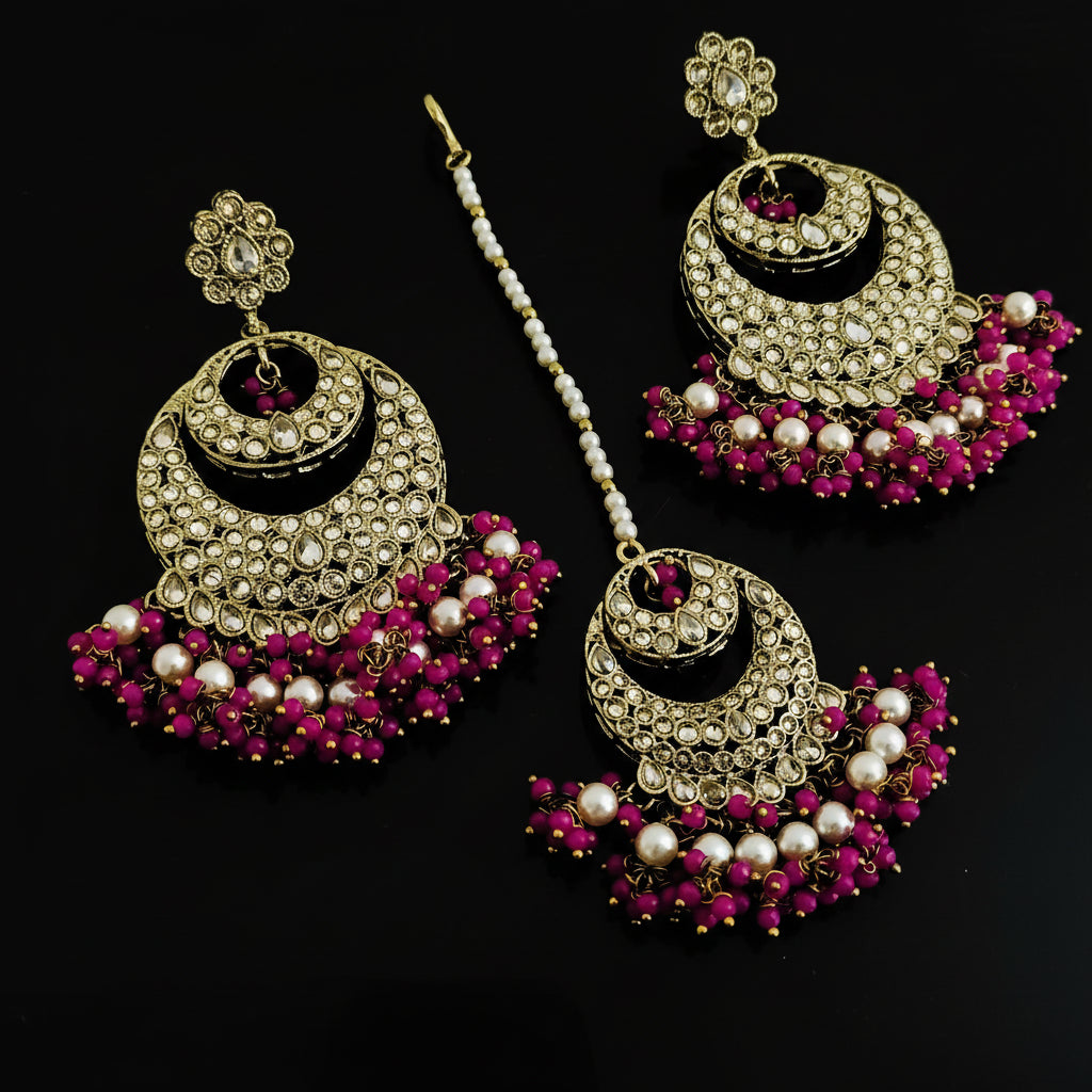 Ornate earrings with pink and white stones on a dark background