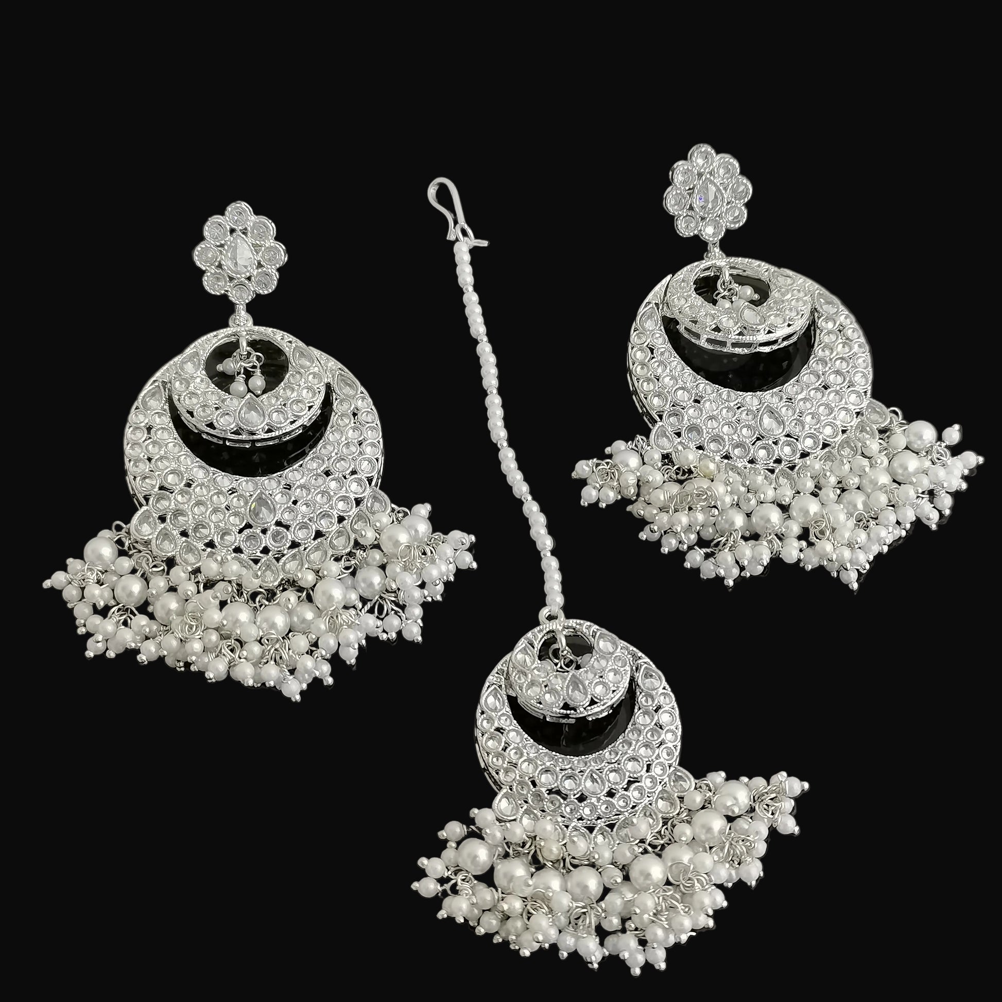 Pair of silver and pearl earrings on a black background
