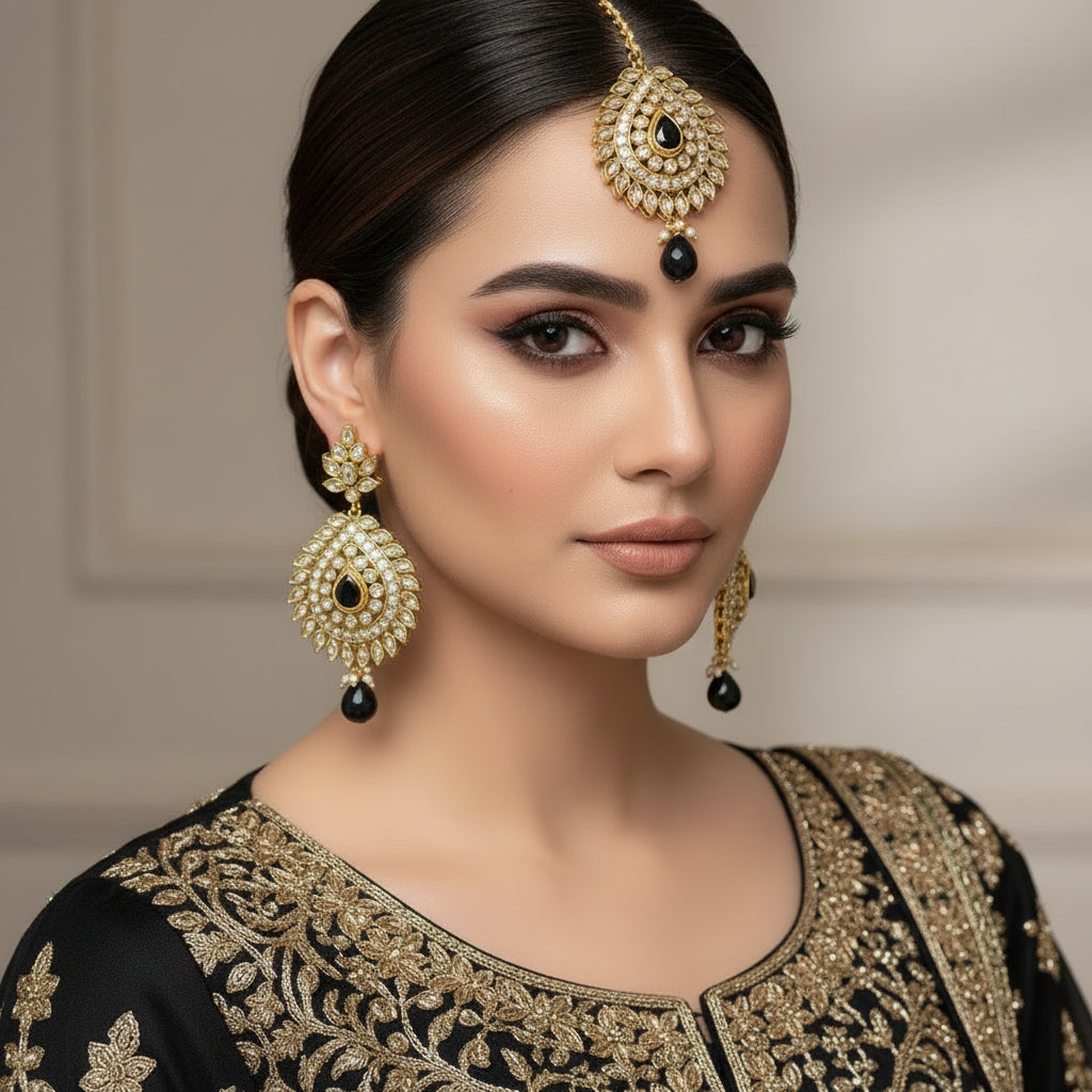 Gold and black jewelry set on a reflective surface with 'SAHELLI' branding.