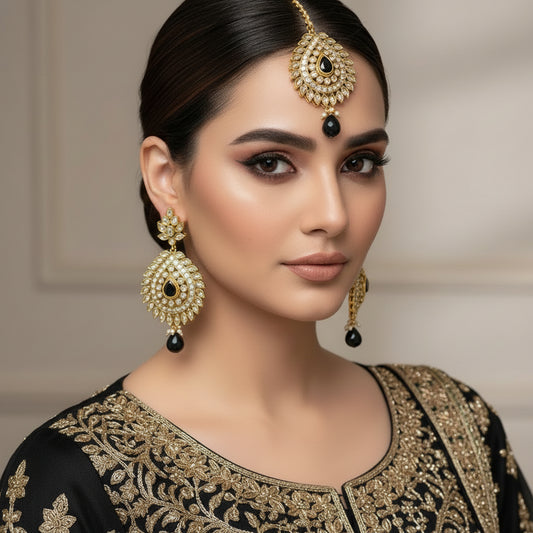 Gold and black jewelry set on a reflective surface with 'SAHELLI' branding.