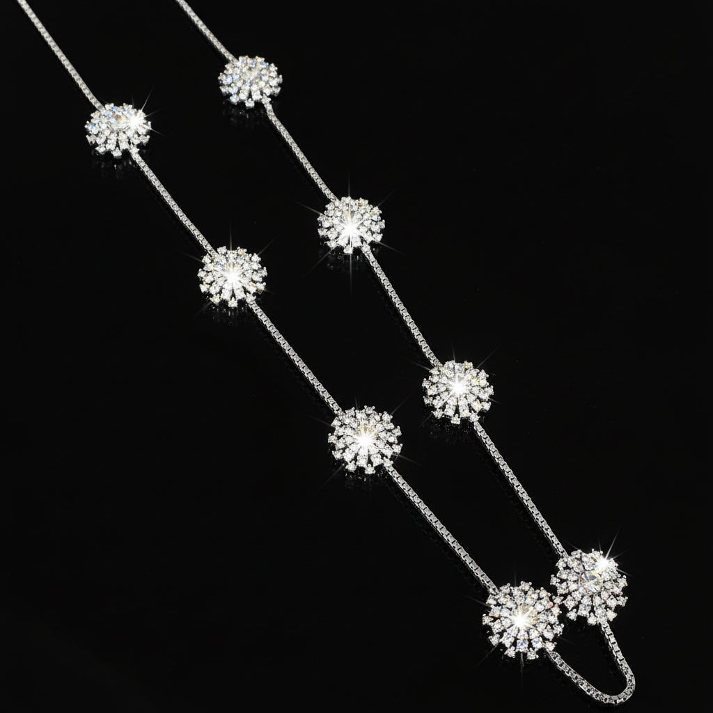 Silver necklace with floral pendants on a gray background, featuring the brand 'Saheli'.