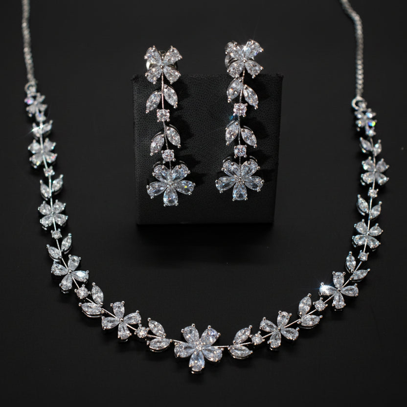 Silver necklace and earrings set on a dark background