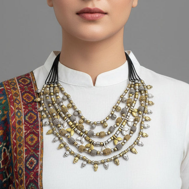 Multiple necklaces with gold and silver beads on a dark background