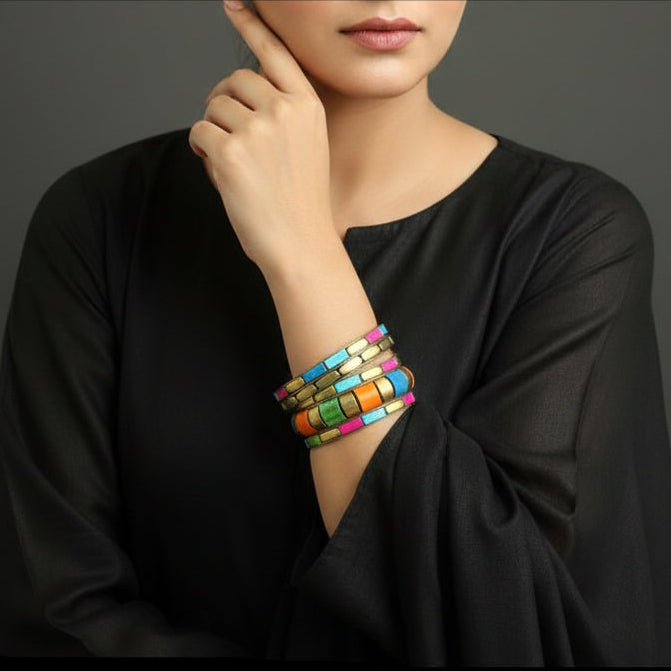 Colorful beaded bracelets on a gray cushion against a dark background
