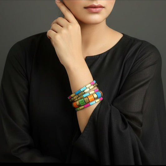 Colorful beaded bracelets on a gray cushion against a dark background