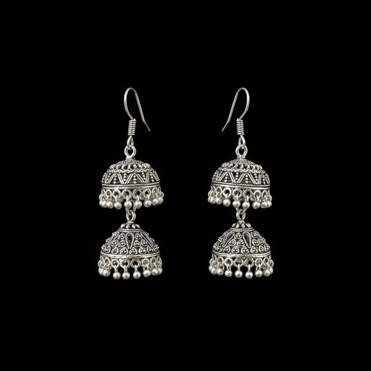 Silver earrings on a gray stand with 'Sahell' branding.