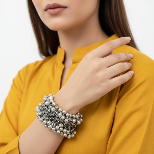 Silver beaded necklace with intricate designs on a gray background, branded 'Saheli'.