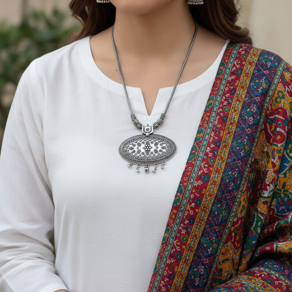 Silver necklace with intricate pendant on a dark background