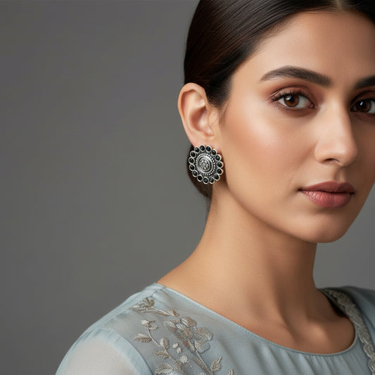 Pair of silver floral earrings on a black background